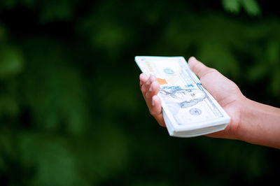 Close-up of hand holding smart phone outdoors