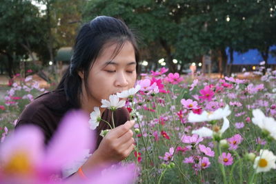 Beautiful young woman with flowers in park