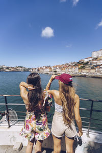 Female friends looking at douro river while spending weekend together in city, porto, portugal