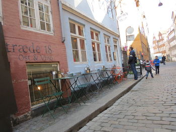 People walking on cobblestone street in city