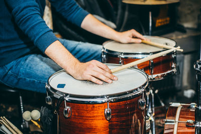 Midsection of man playing guitar at music concert