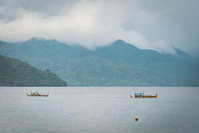 Scenic view of sea and mountains against sky