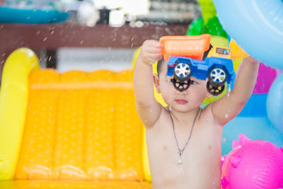 Shirtless boy playing with toy in water park