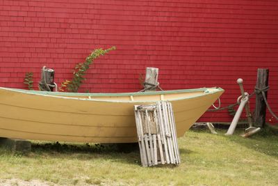 Wooden boat moored against red brick wall