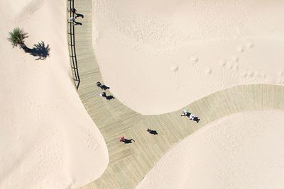 High angle view of people walking on boardwalk at desert during sunny day