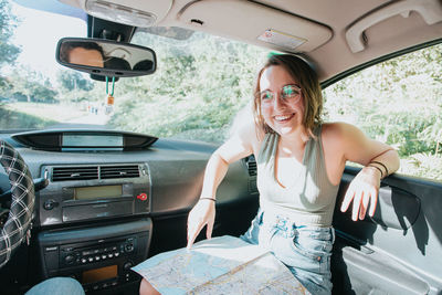 Portrait of young woman sitting in car