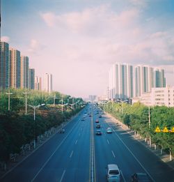 View of city street against cloudy sky