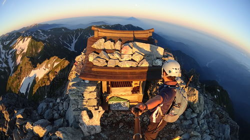 Man standing on mountain during sunset