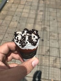 Close-up of hand holding ice cream cone outdoors