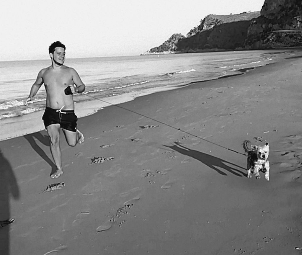 FULL LENGTH OF SHIRTLESS ON BEACH AGAINST SKY