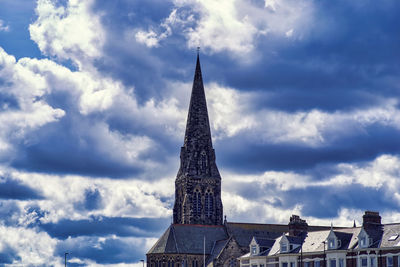 Low angle view of buildings against cloudy sky