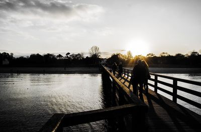 Pier on lake at sunset