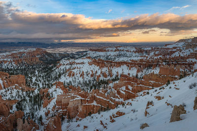 Aerial view of snowcapped mountains against sky during sunset