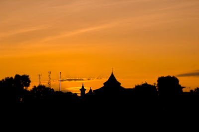 Silhouette of temple building against sky during sunset