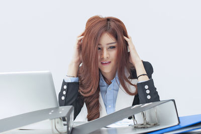 Young woman using phone while sitting on table