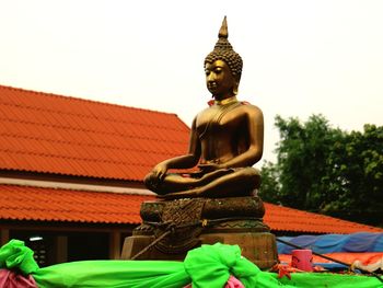 Low angle view of statue against temple building against sky