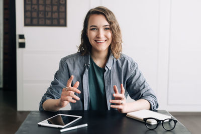 Portrait of young businesswoman using laptop at office