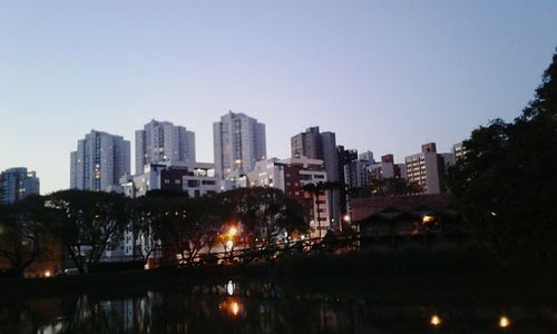 Illuminated cityscape against clear sky at night