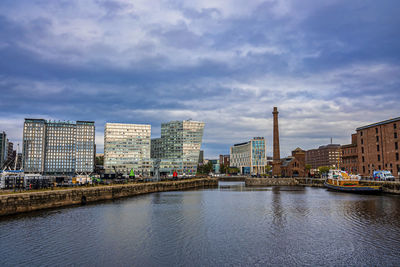 Liverpool waterfront with modern city buildings against cloudy sky