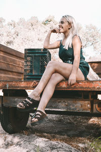 Portrait of woman sitting on bench in park