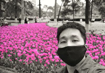 Portrait of person on pink flowering plants