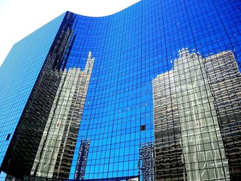 Low angle view of office building against blue sky