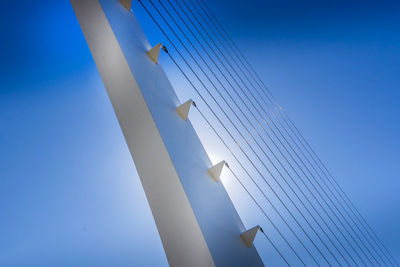 Low angle view of cable-stayed bridge against blue sky