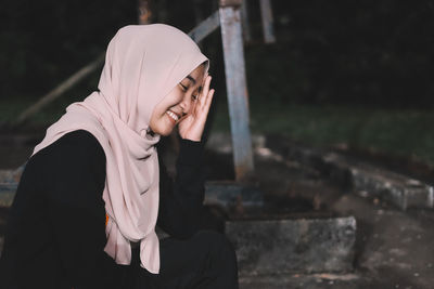 Smiling woman wearing hijab at park