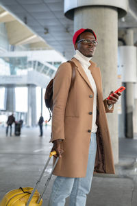 Man with smart phone standing at airport