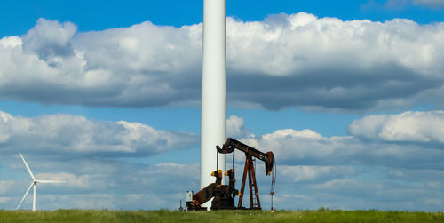 Traditional windmill on field against sky