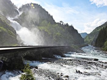 Scenic view of waterfall against sky