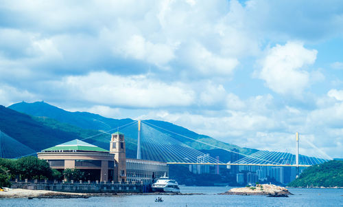 Scenic view of buildings by mountains against sky