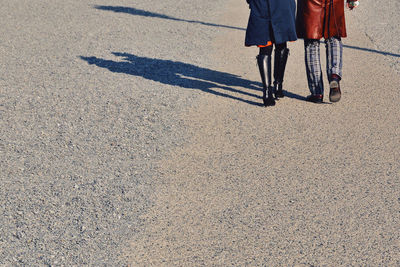 Low section of woman walking on road