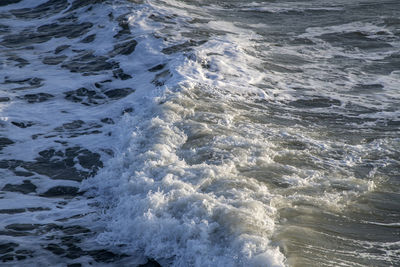 High angle view of waves rushing towards shore