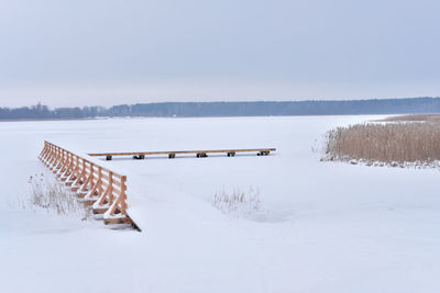 Scenic view of snow covered field against sky