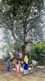 Rear view of people walking on tree