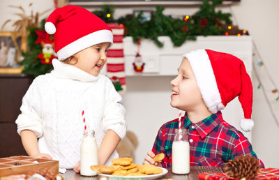 Smiling sibling having cookies at home