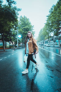 Full length portrait of young woman in city