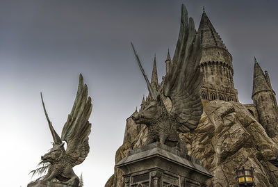 Low angle view of statue of historic building against sky