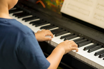 Midsection of man playing piano