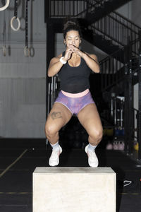 Latin woman doing box jumps at crossfire gym