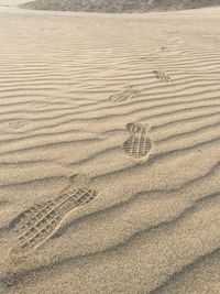 High angle view of footprints on sand at beach