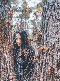 Portrait of young woman in tree trunk