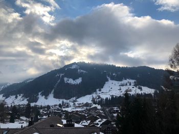 Houses by mountains against sky during winter