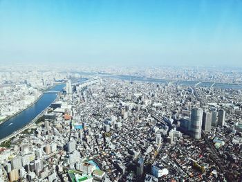 High angle view of city buildings against blue sky