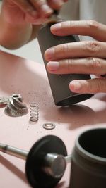 Cropped hands of man cleaning a manual coffee grinder