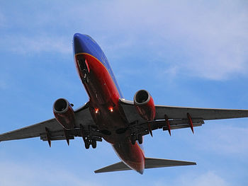 Low angle view of airplane flying against sky