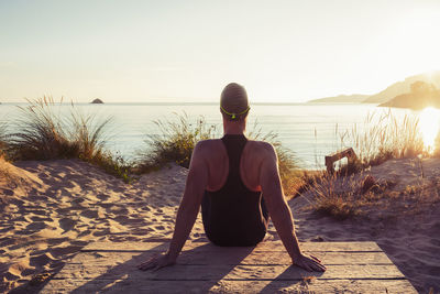 Rear view of man on beach against sky