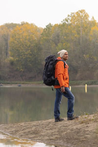 Portrait of traveler man at lake in autumn