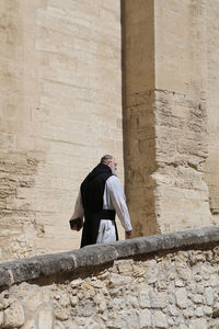 Low angle view of man standing against wall